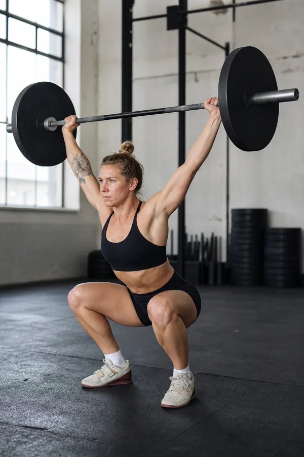 CrossFit athlete holding a barbell overhead in an overhead squat position