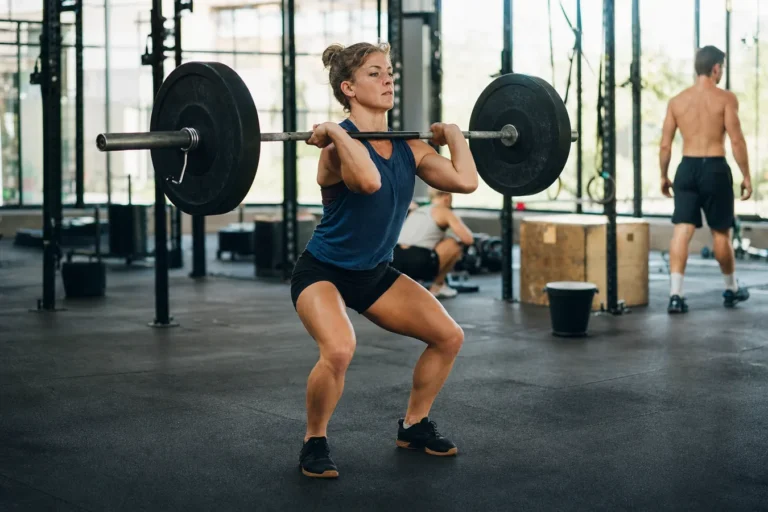 CrossFit athlete practicing the dip and drive for a barbell push jerk in a functional fitness gym