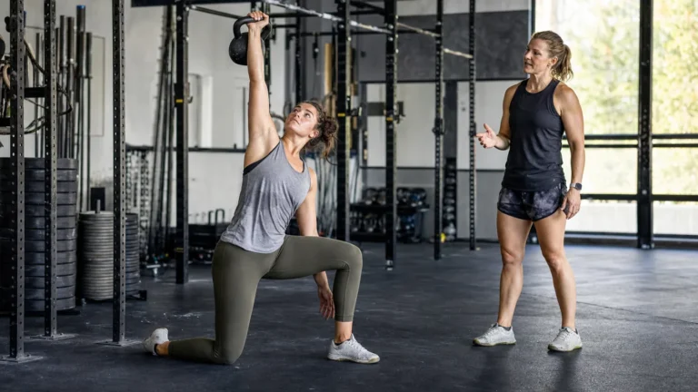 CrossFit athlete performing a controlled Turkish get-up with a kettlebell in a gym