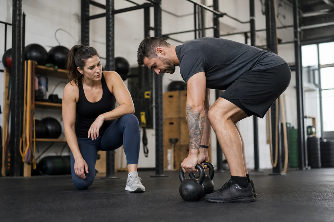 CrossFit athlete setting down kettlebells after a farmer carry under control