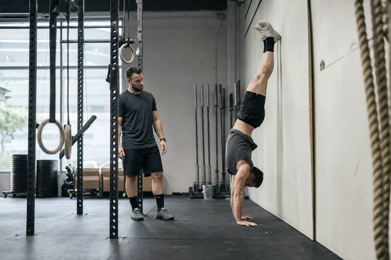 CrossFit athlete practicing a handstand push-up against a wall