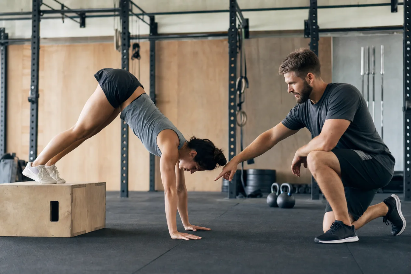 Athlete scaling handstand push-ups with a pike push-up on a box