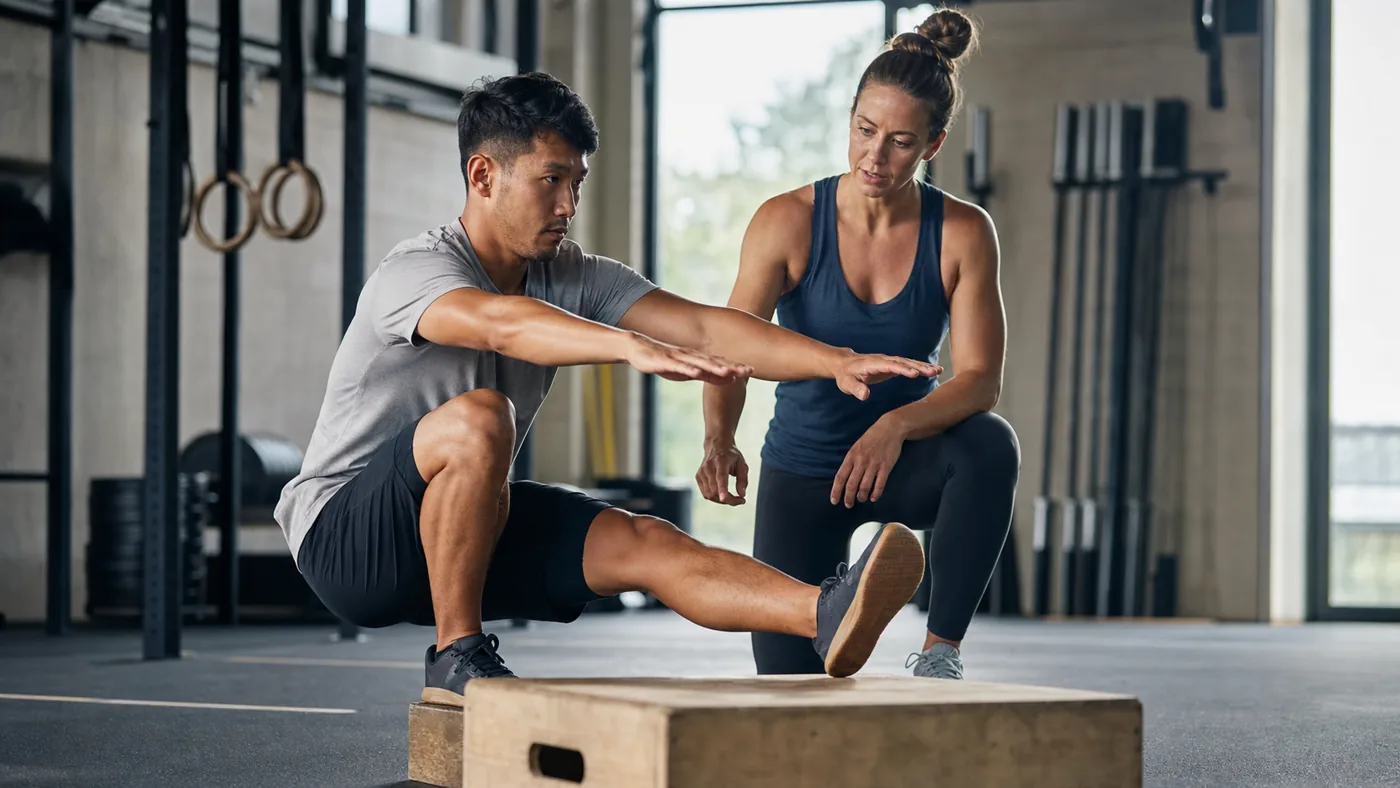 CrossFit athlete practicing a controlled pistol squat to a box