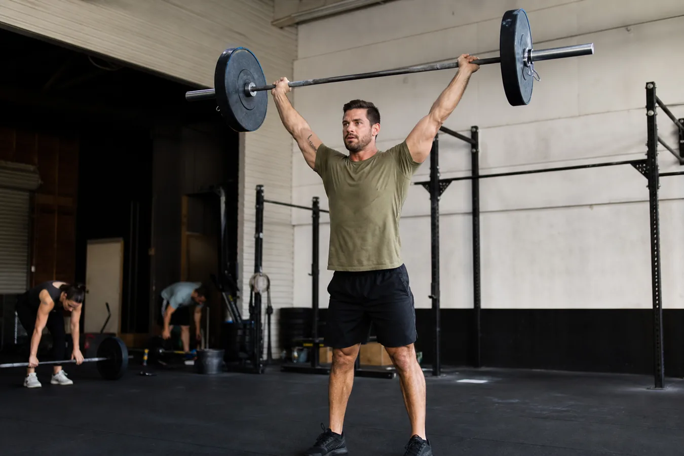 CrossFit athlete receiving a push jerk overhead with locked elbows and stable feet