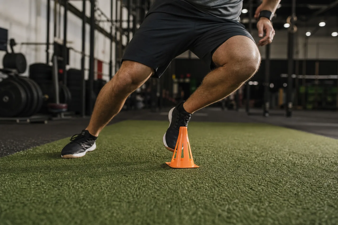Athlete planting the foot around a cone during a CrossFit shuttle run
