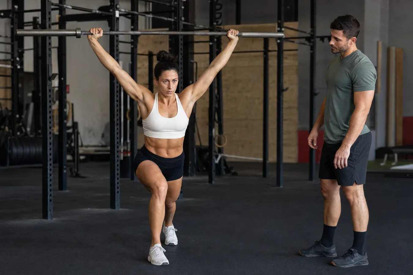 CrossFit athlete drilling snatch balance footwork with an empty barbell