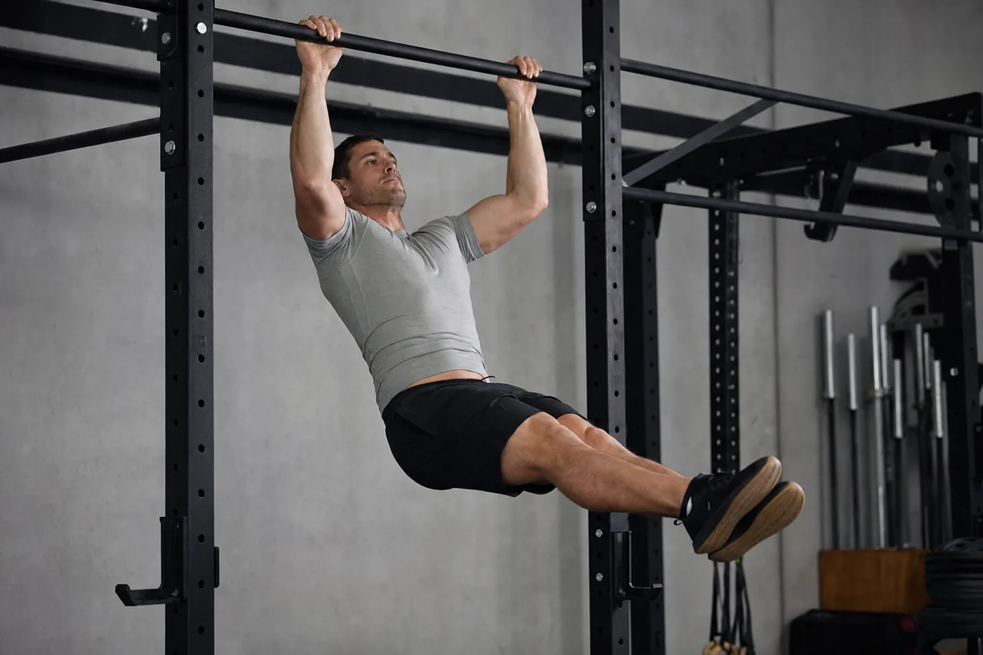 CrossFit athlete performing a strict pull-up on a gym rig
