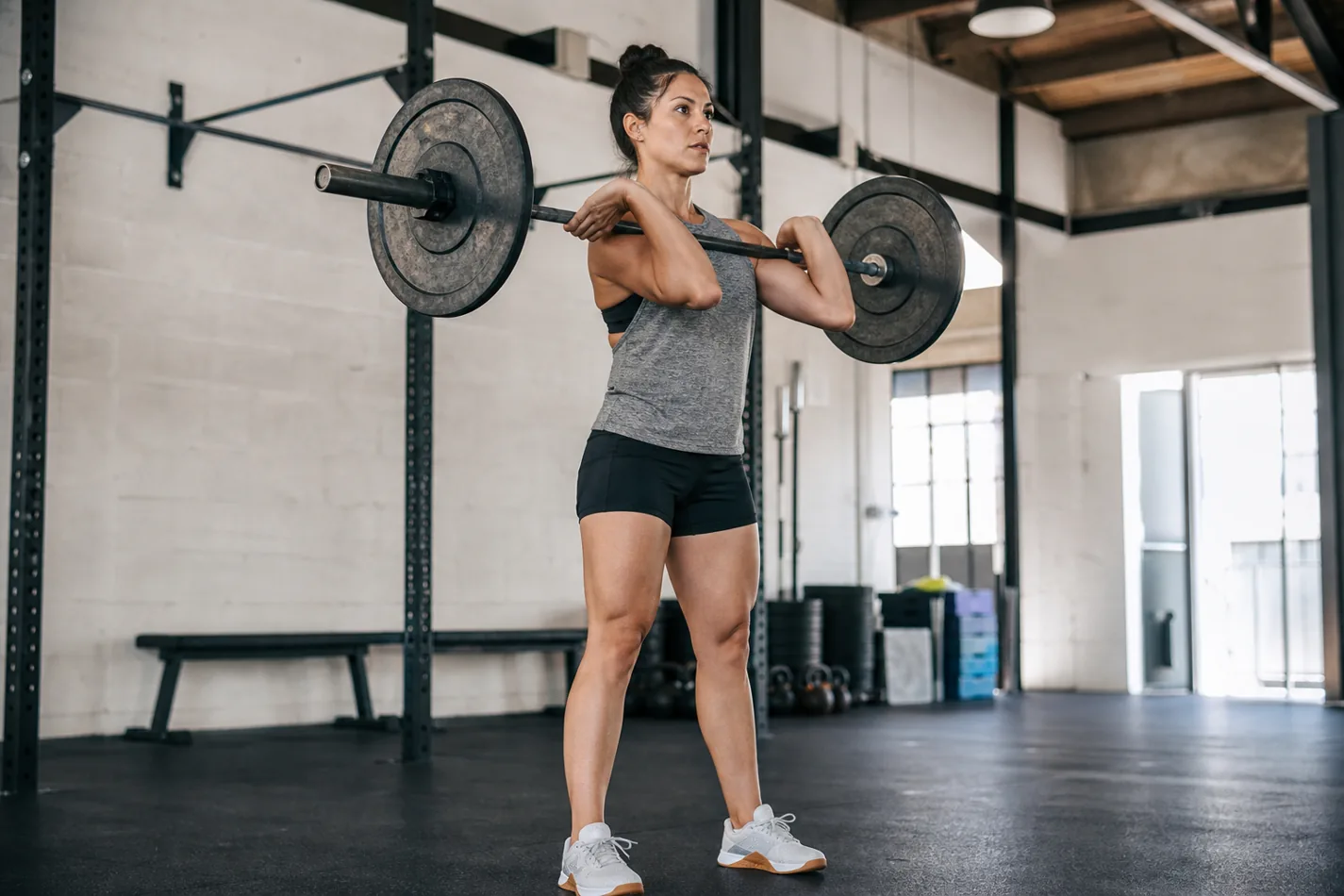 CrossFit athlete preparing for a Bear Complex barbell sequence in a gym