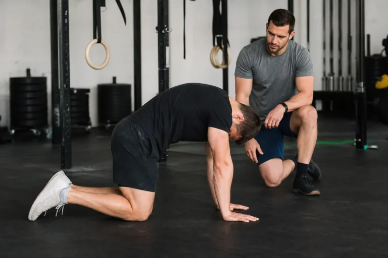 CrossFit athlete doing cat cow stretch during a gym warm-up