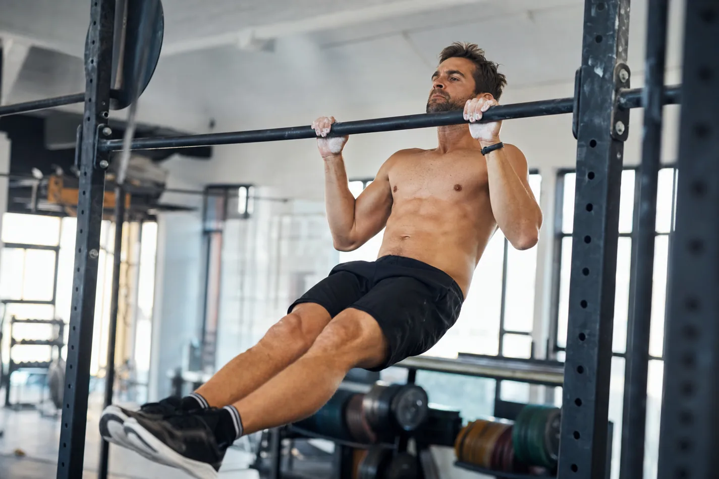 CrossFit athlete performing a chest-to-bar pull-up on a rig