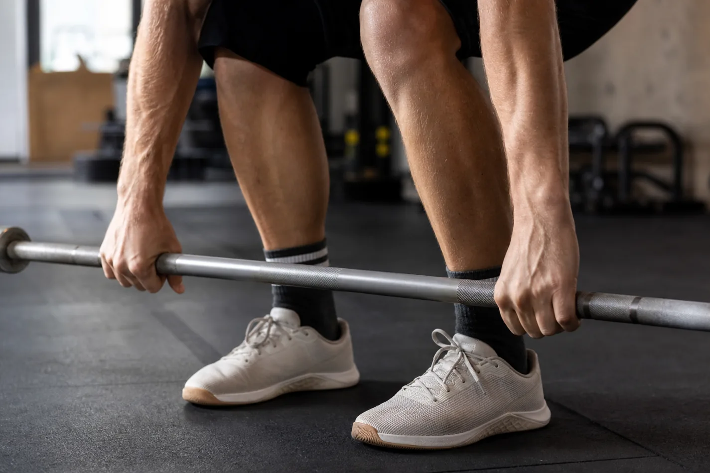 CrossFit athlete practicing barbell cycling footwork and grip with an empty barbell