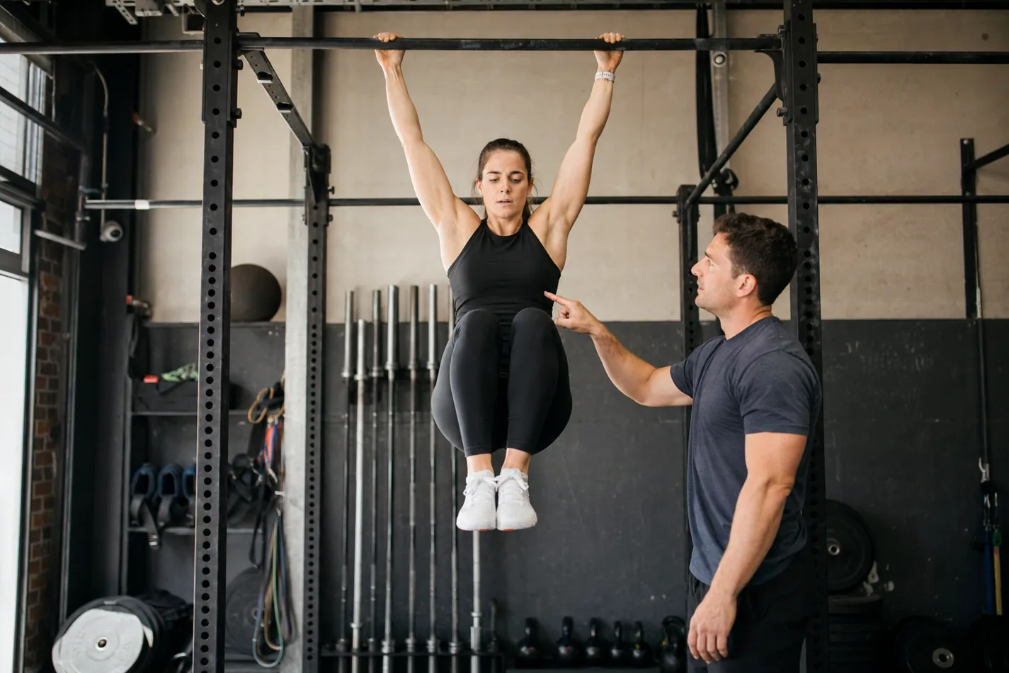 Athlete practicing a controlled hanging knee raise before knees-to-elbows