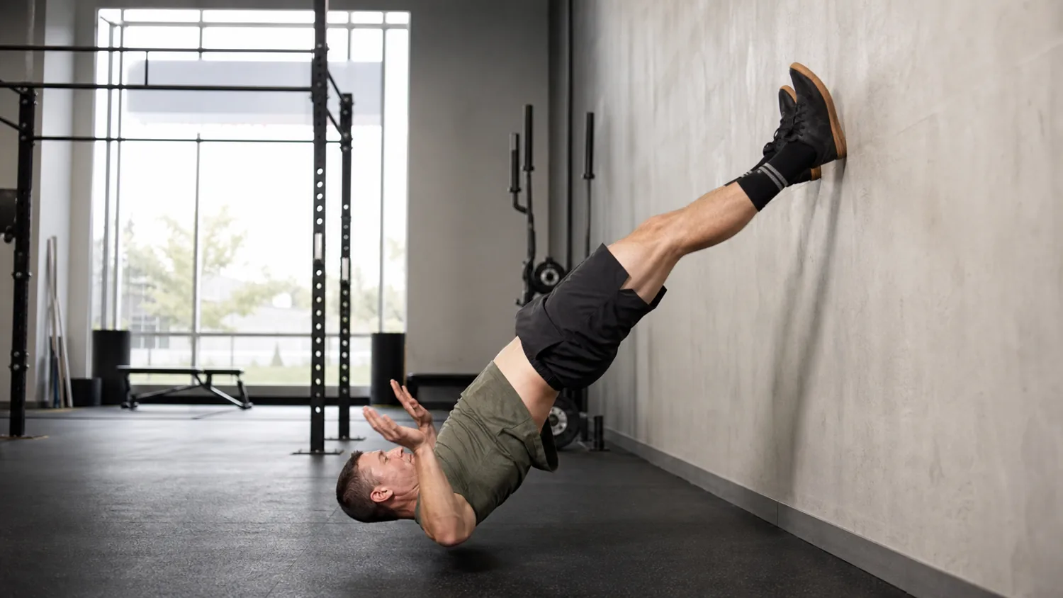 Athlete practicing an inverted burpee kick-up in a CrossFit gym