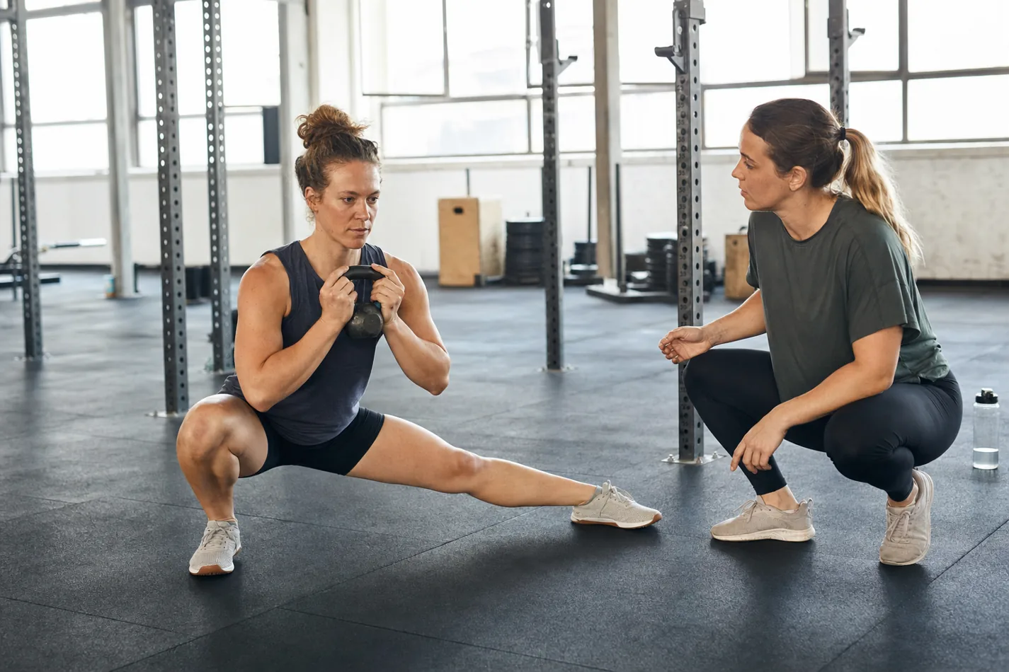 CrossFit athlete holding a light kettlebell during a controlled Cossack squat