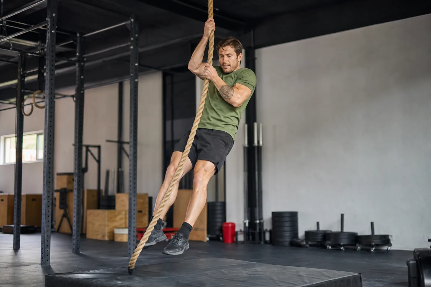 CrossFit athlete descending a legless rope climb with control