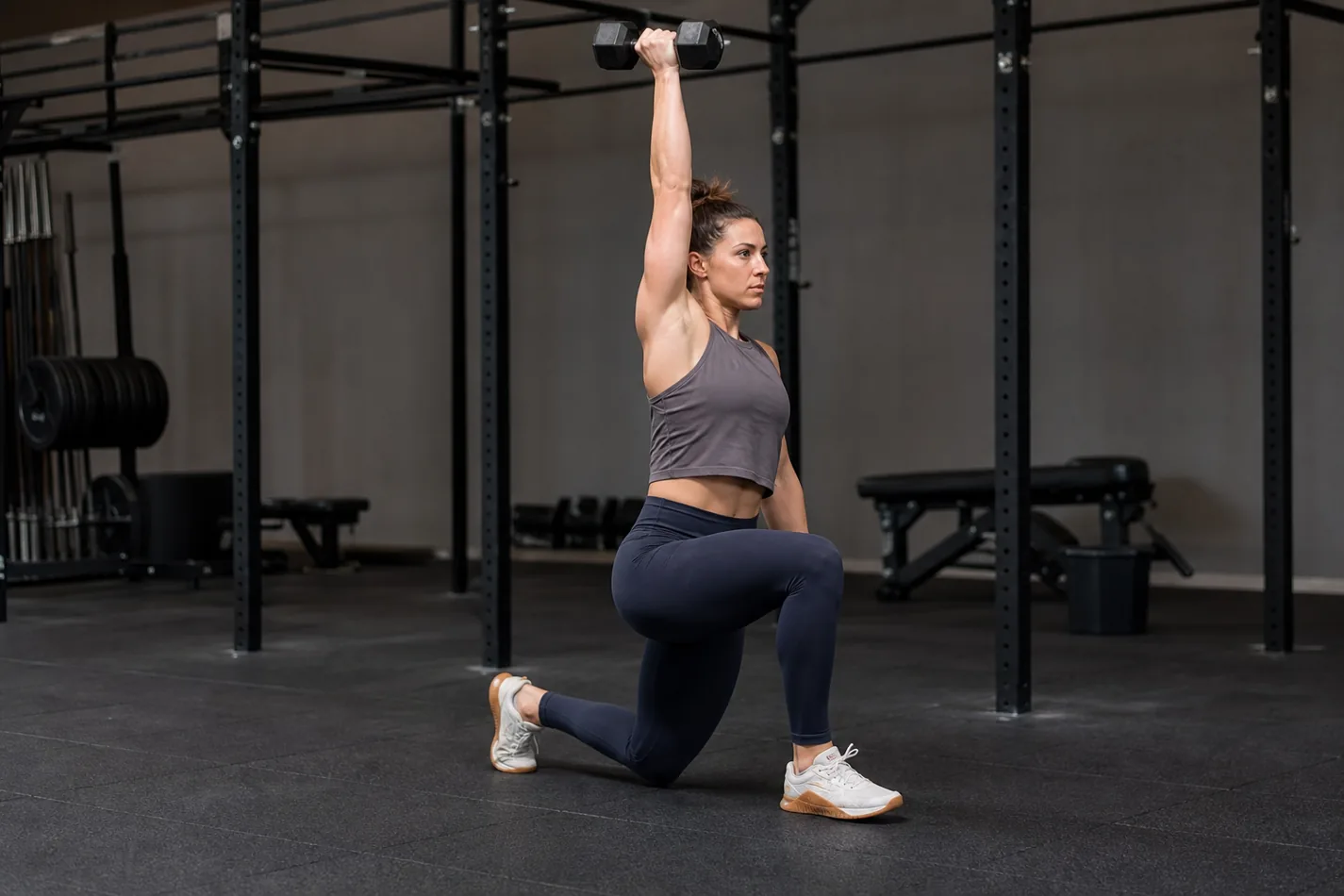 CrossFit athlete performing an overhead walking lunge with a dumbbell