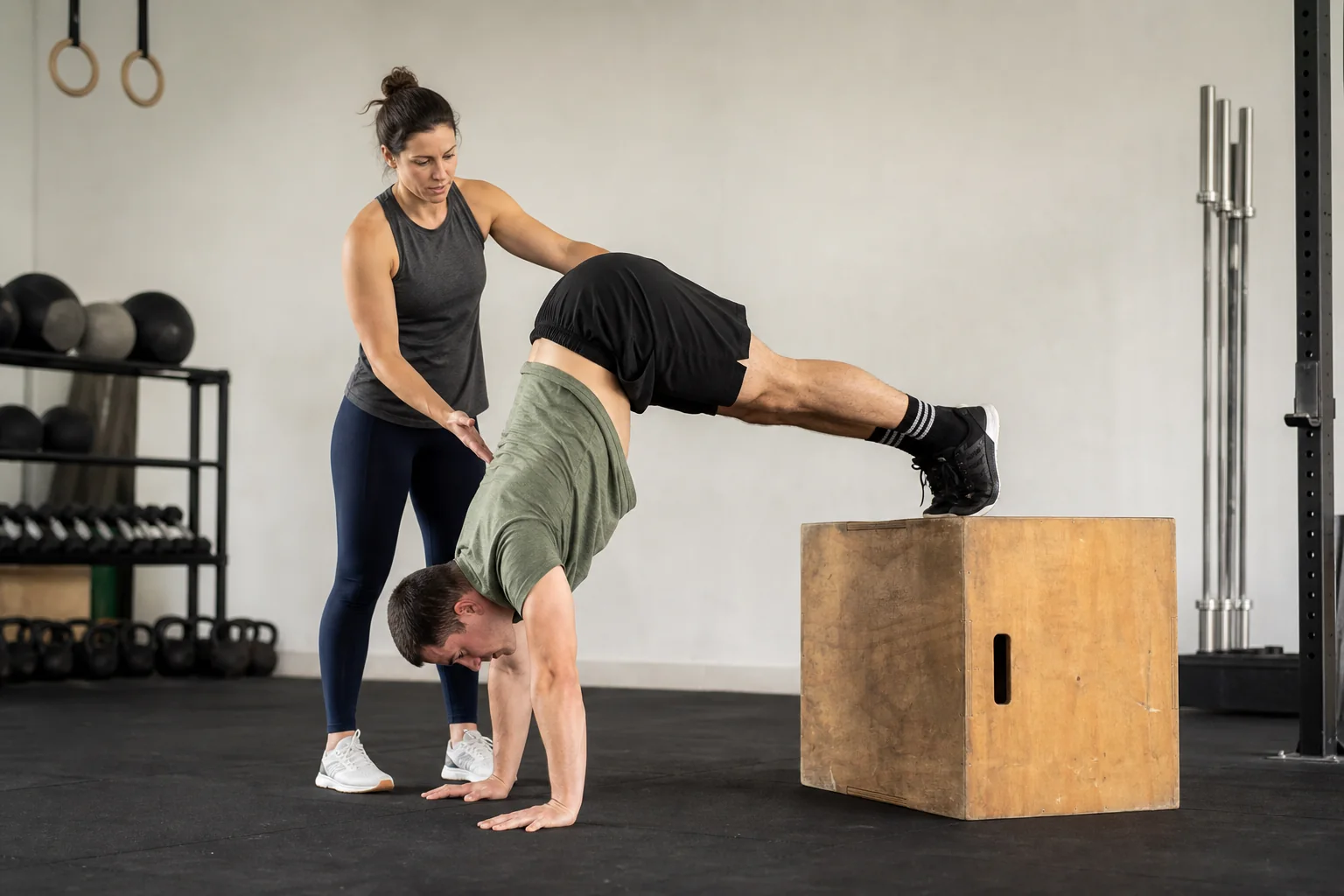 Athlete practicing a pike handstand hold with feet on a box
