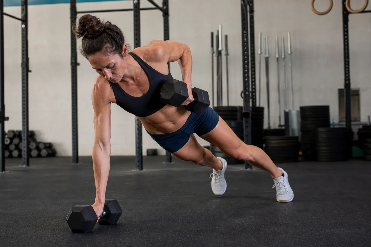 CrossFit athlete holding a strong plank for a dumbbell renegade row