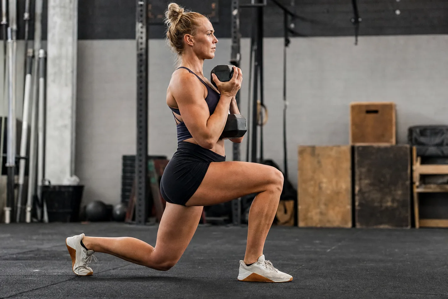 CrossFit athlete stepping backward into a goblet reverse lunge with an upright torso