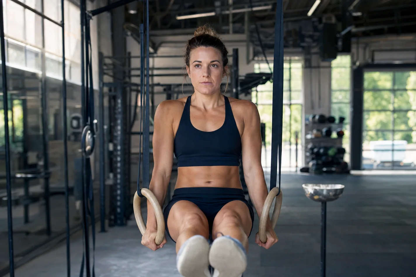 CrossFit athlete holding a stable support position on wooden gymnastic rings