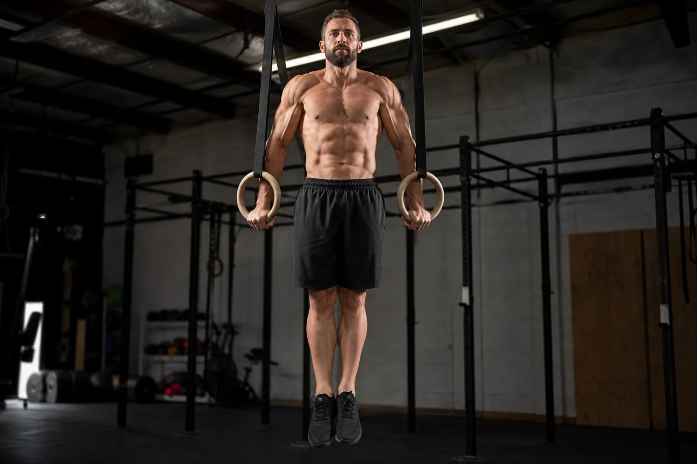 CrossFit athlete holding a stable top support position on gymnastic rings