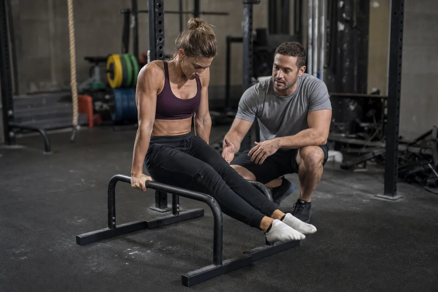 CrossFit athlete scaling a parallette shoot-through with controlled foot contact