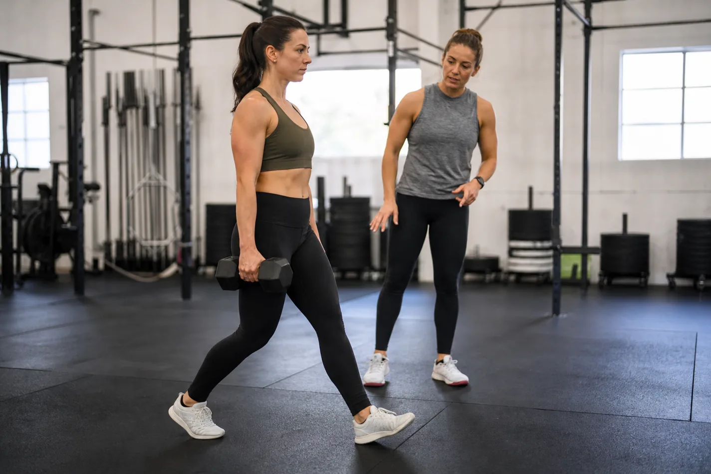 CrossFit athlete practicing a single-arm dumbbell suitcase carry with shoulders level