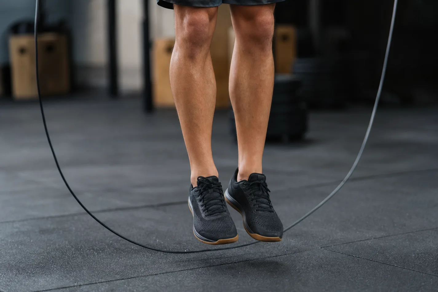 CrossFit athlete doing low single under jumps with the rope clearing the toes